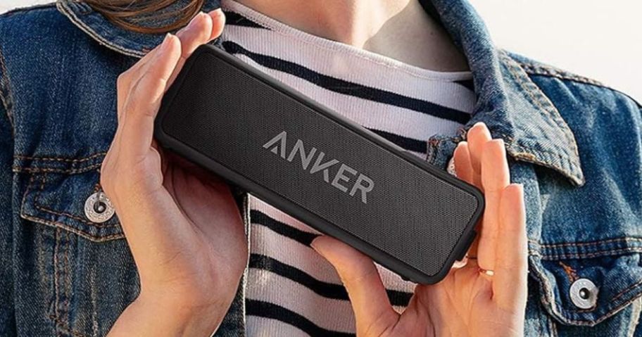 Anker Soundcore 2 Portable Bluetooth Speaker with 12W Stereo Sound being held between woman's hands against her body