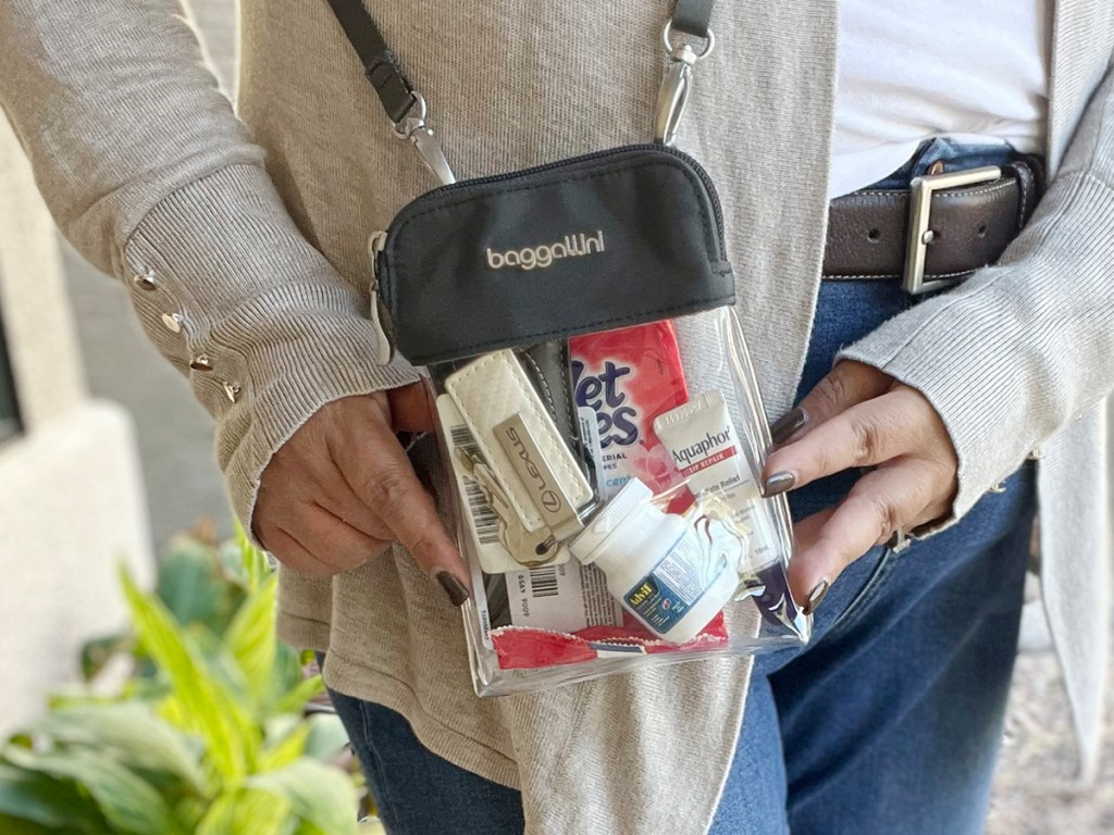 woman holding clear bryant baggallini bag full of products
