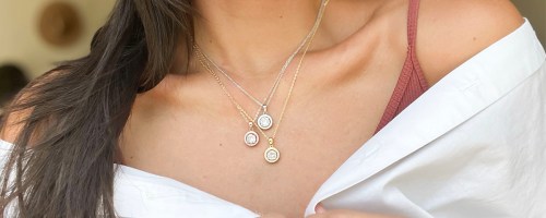 woman wearing three pendant necklaces and button shirt
