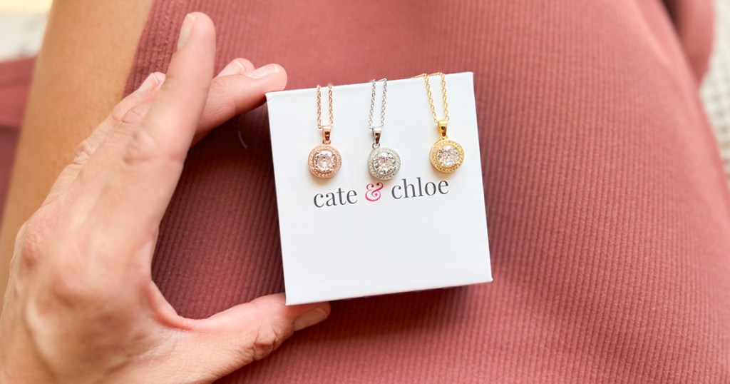 hand holding 3 cate and chloe necklaces