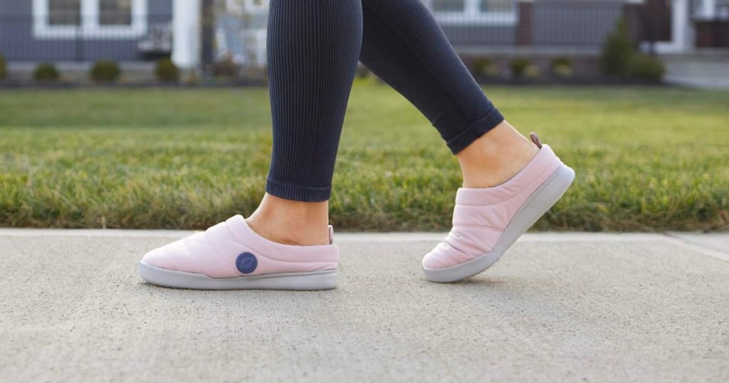 woman wearing pink slippers walking on sidewalk