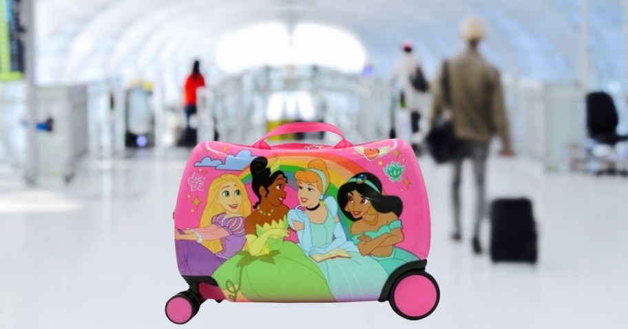 disney princess ride on suitcase with blurry airport in background