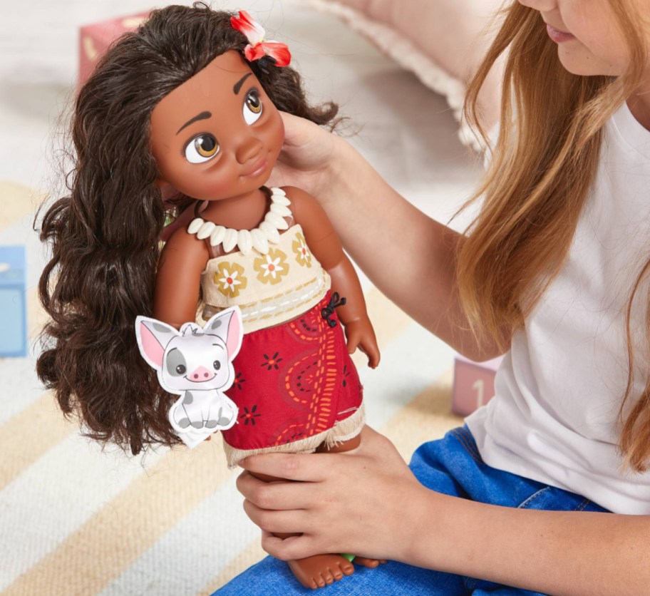 girl playing with large moana doll