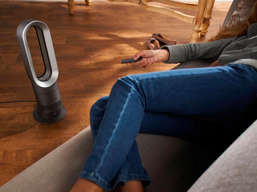 gray bladeless dyson fan pointed at woman on couch