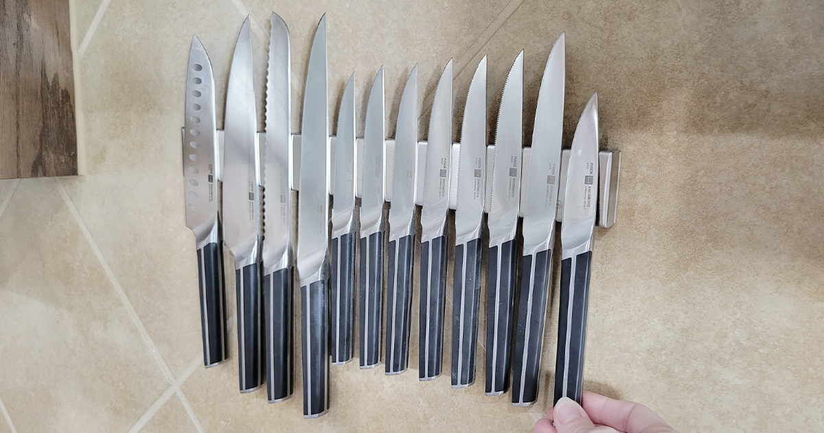 set of knives hanging on magnetic knife holder on wall