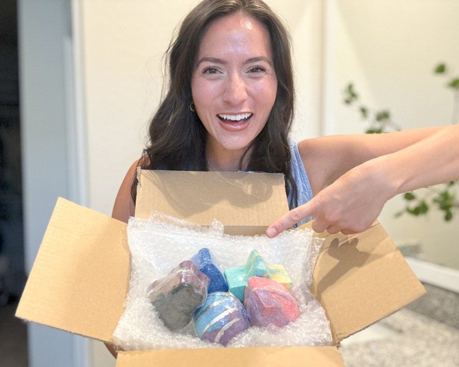 woman pointing to box of bath bombs