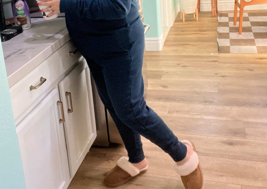 woman standing at counter with navy blue joggers