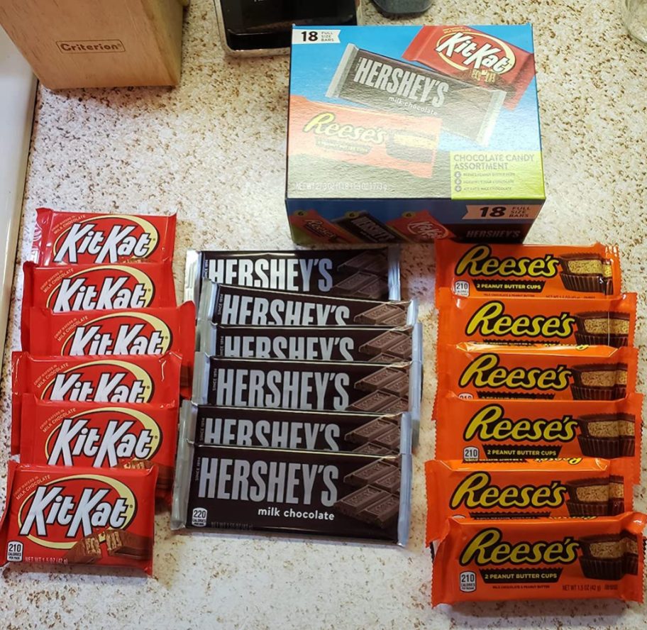 hershey's candy box with kit kats, hershey bars, and reeses laid out in front of it on countertop
