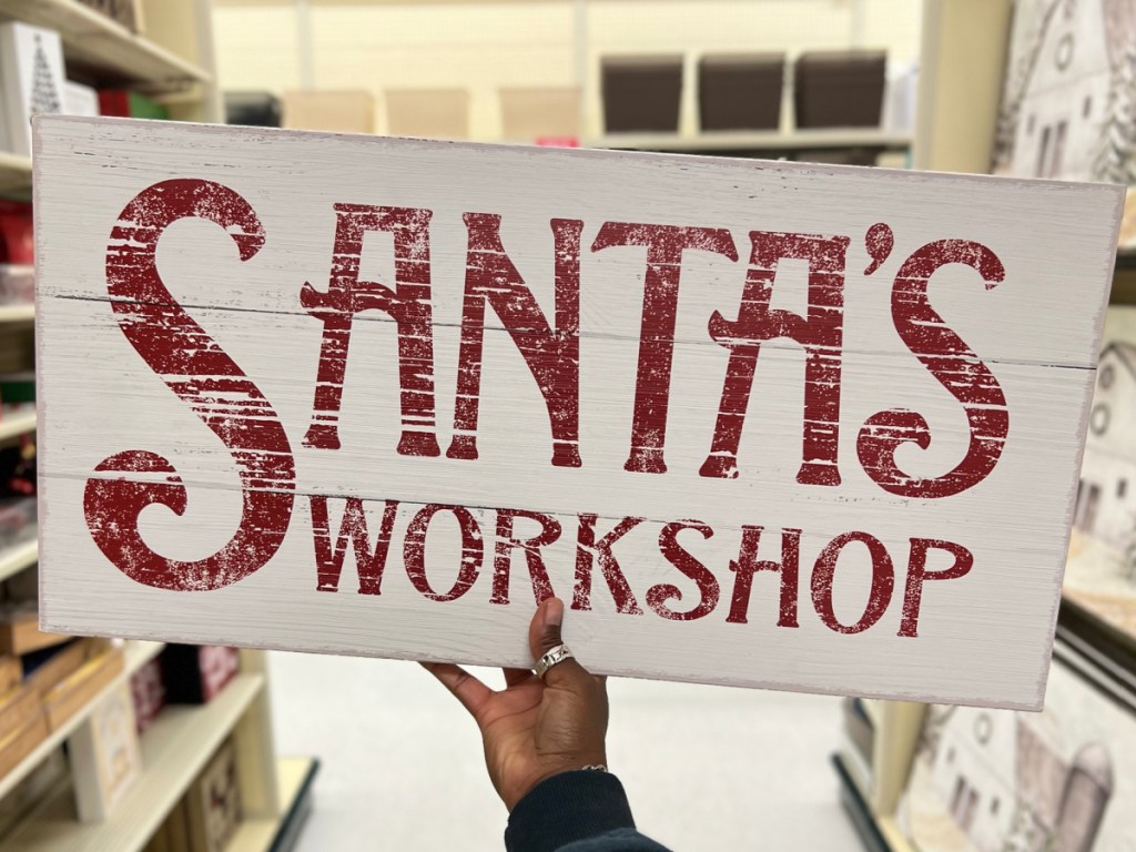 hand holding Santas workshop sign in the store