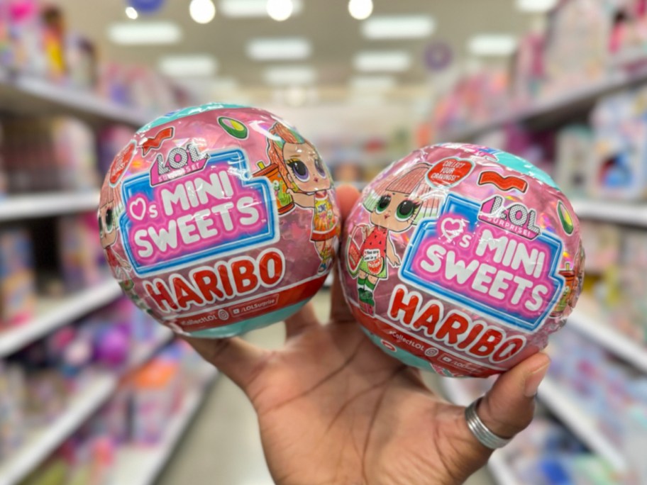 hand holding two L.O.L. Surprise! Loves Mini Sweets X Haribo with 7 Surprises