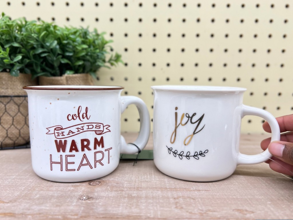 https://hip2save.com/wp-content/uploads/2023/12/hand-holding-two-ceramic-holiday-mugs.jpg?resize=1024%2C768&strip=all