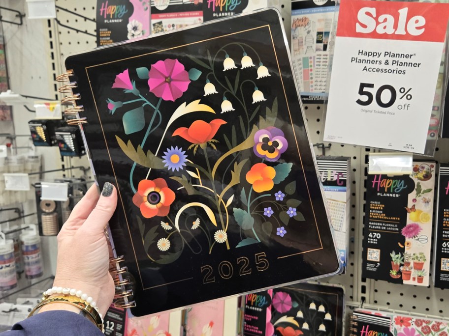 hand holding black floral planner 