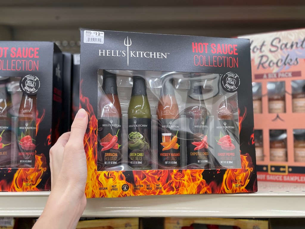 hand holding hells kitchen hot sauce collection 