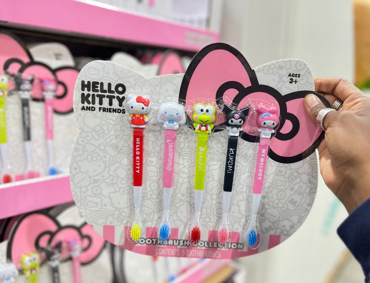 a woman's hand displaying at hello kitty 5 pack toothbrush set