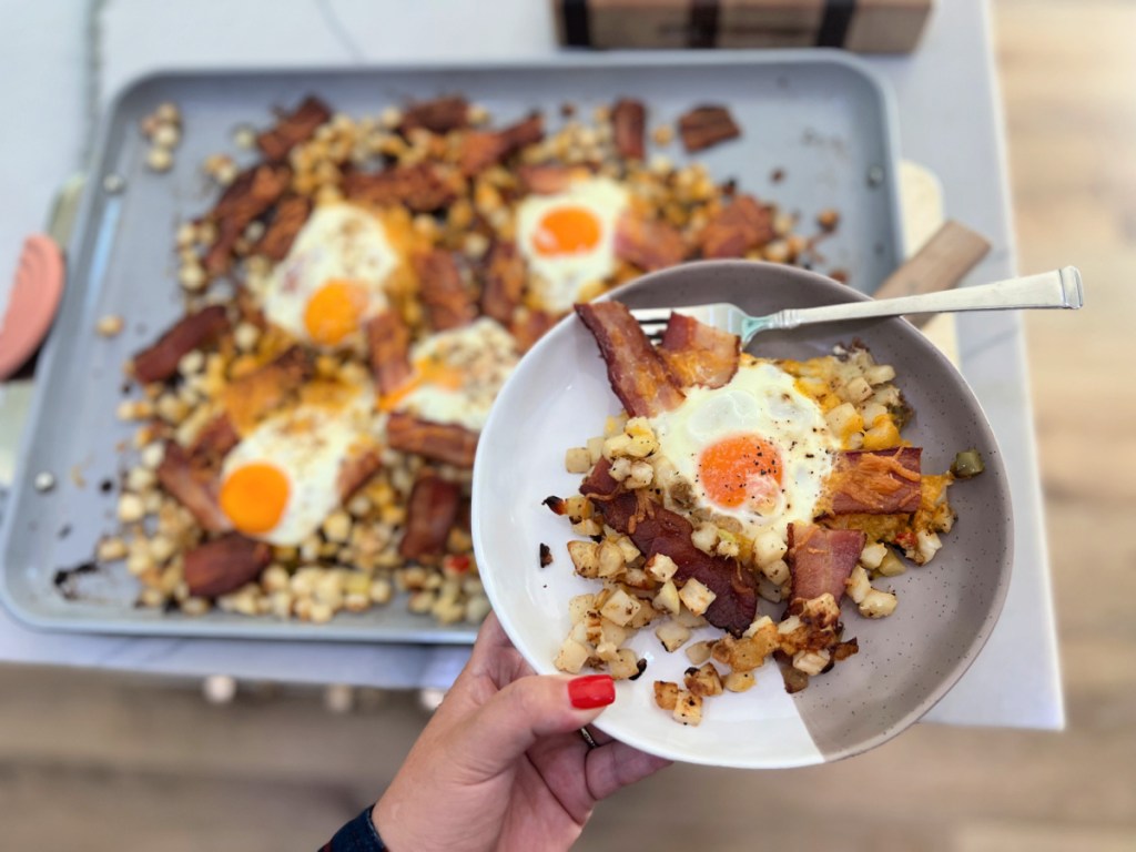 holding a plate with a serving of sheet pan breakfast