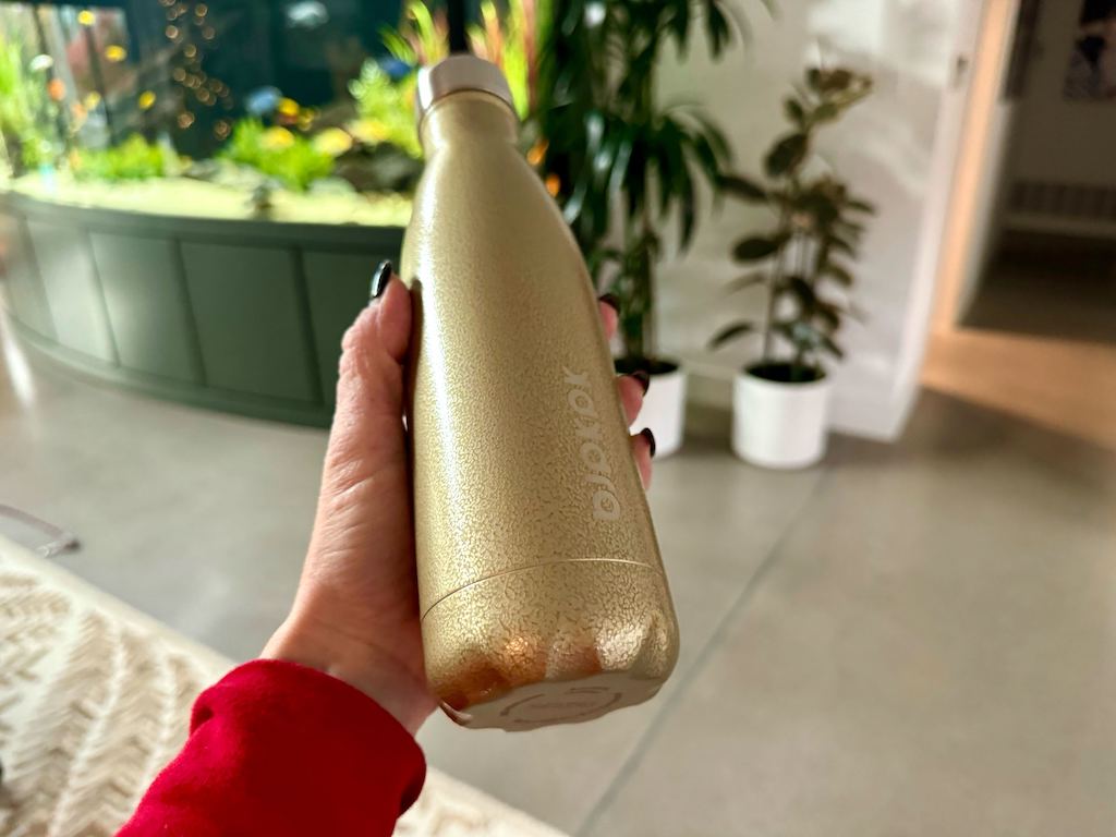 holding gold water bottle 