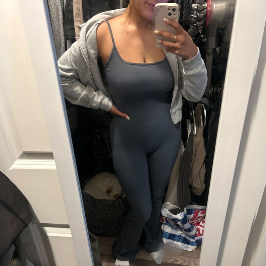 a woman wearing a dark gray tanktop jumpsuit with a heather gray fullzip hoodies