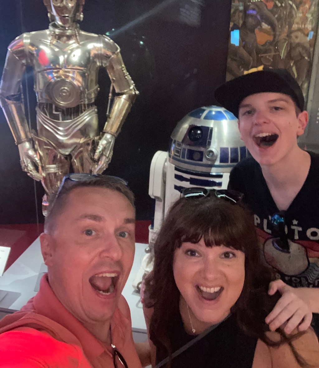 couple and teen son taking selfie with star wars characters