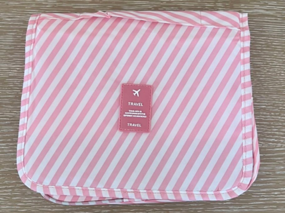 pink and white striped toiletry bag sitting on table