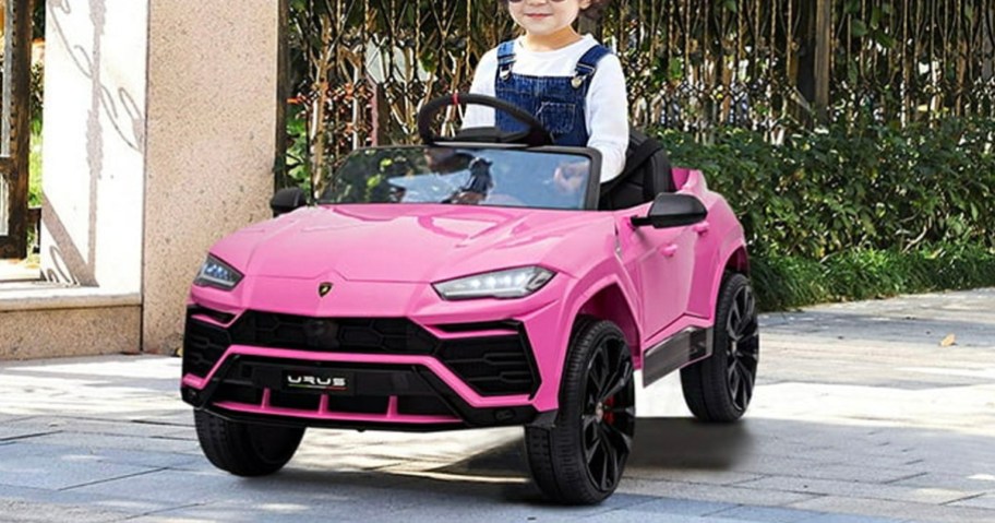 child riding in pink lamborghini car on sidewalk