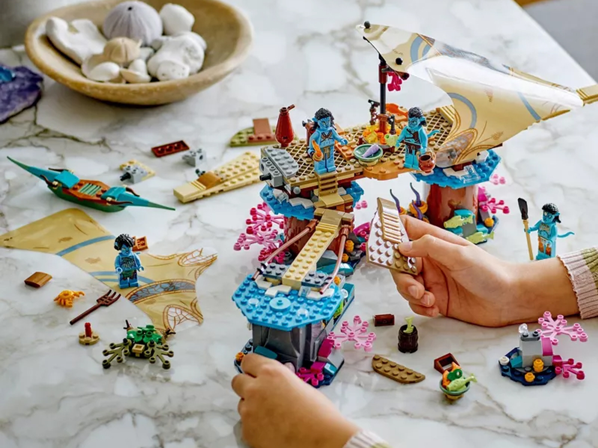 hands building lego avatar set on table