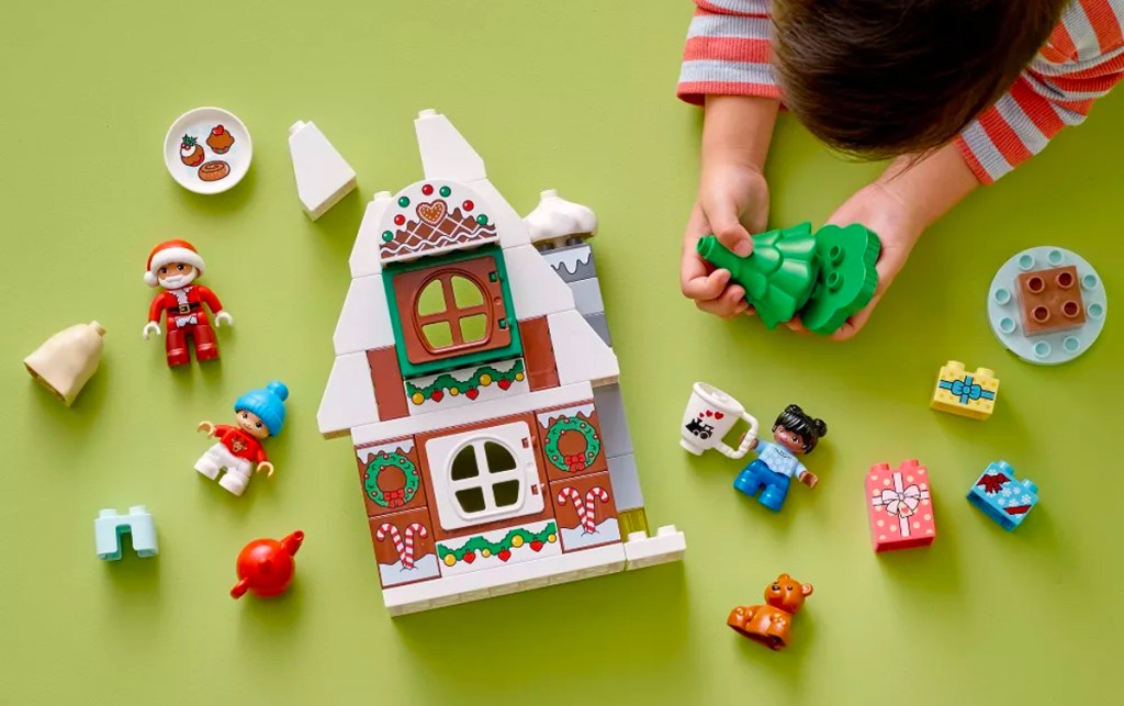 boy playing with lego gingerbread house set