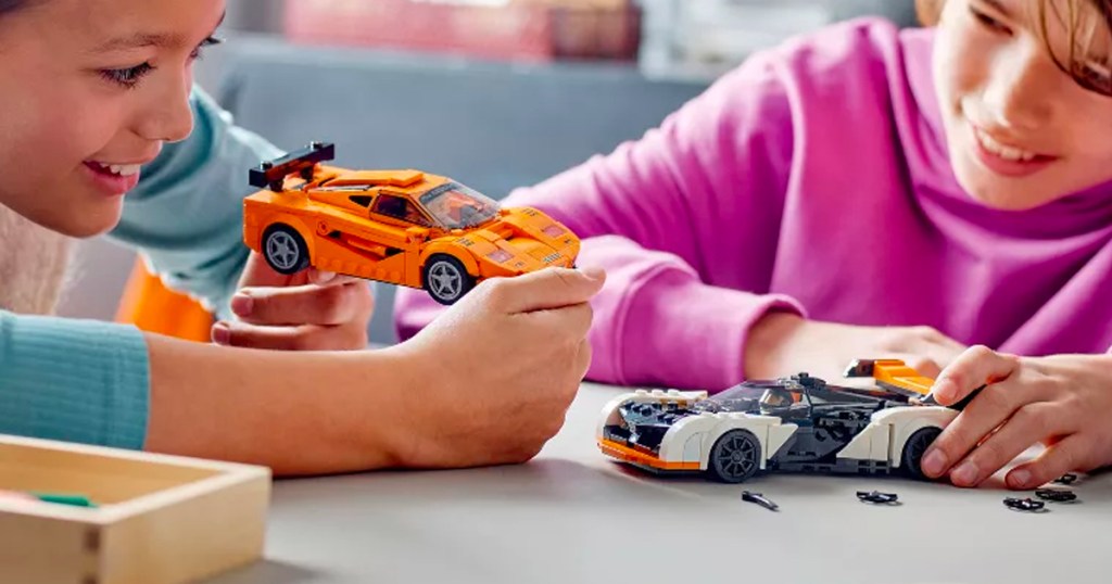two kids playing with lego mcclaren set