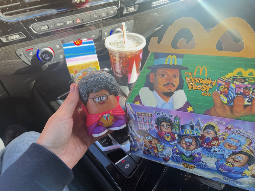 mcdonalds adult happy meal in a car and nugget buddy in a woman's hand