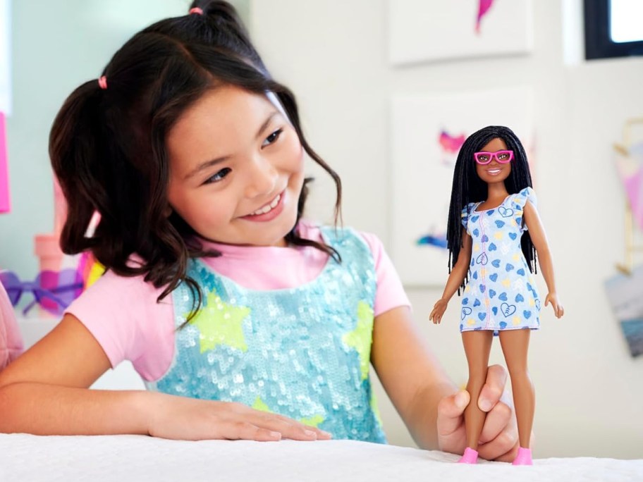 smiling girl with black barbie with down syndrome