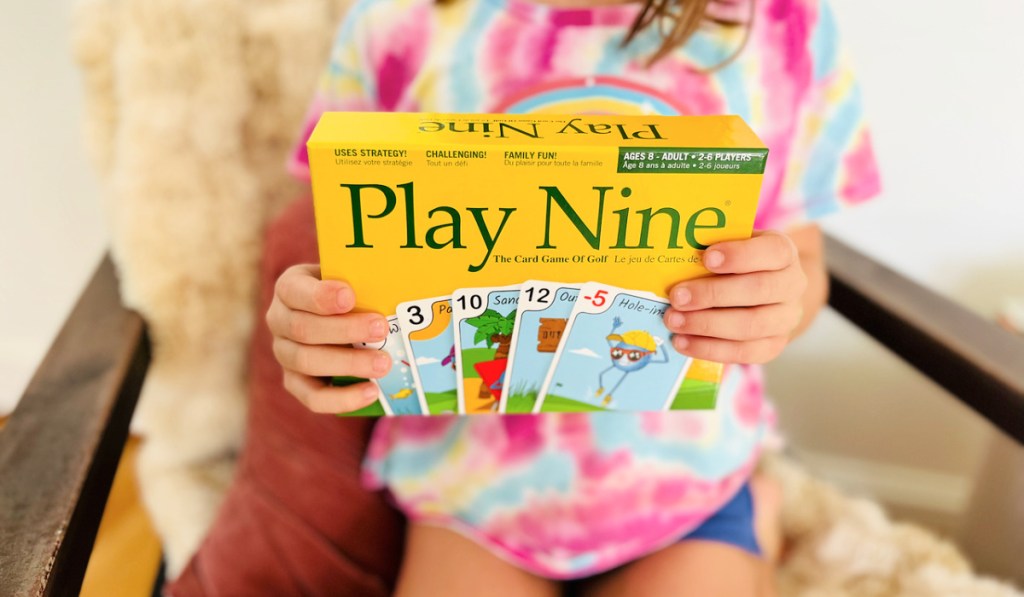 girl holding a play nine card game box