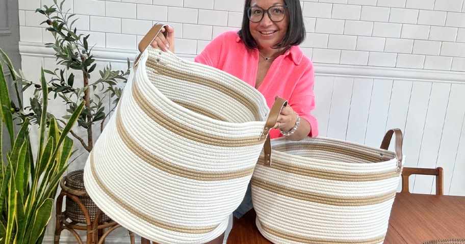 woman holding beige and tan rope basket with smaller basket on table