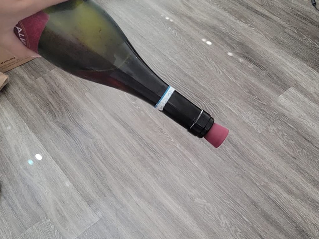 holding a wine bottle upside down