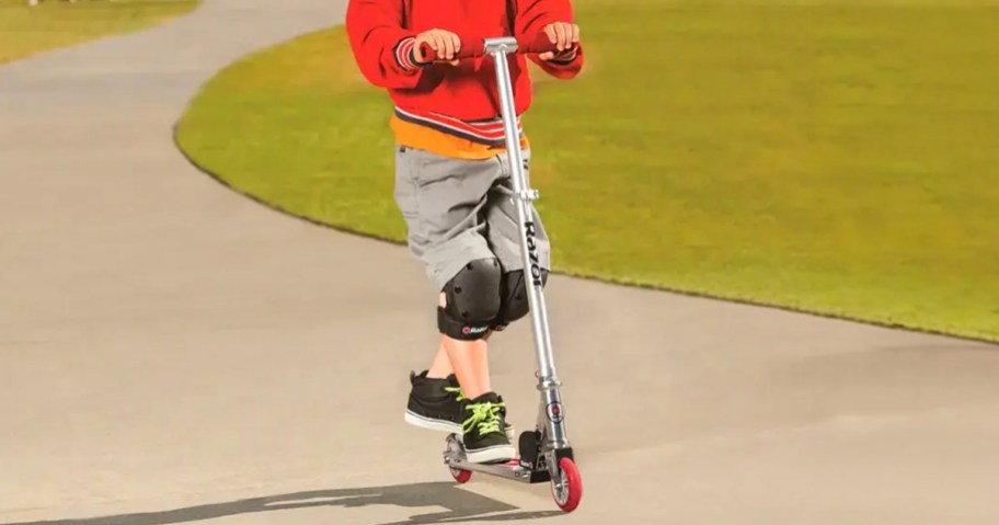 kid riding on red razor scooter