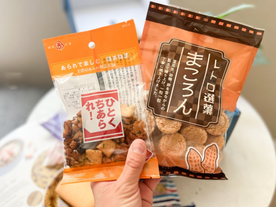hand holding two bags of japanese treats