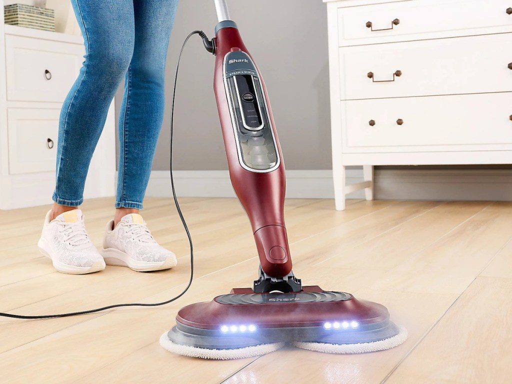 woman using red steam mop on floors