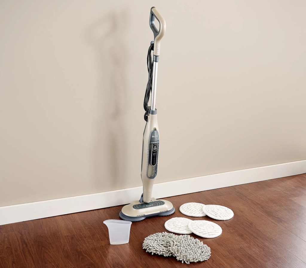white steam mop with extra pads on floor