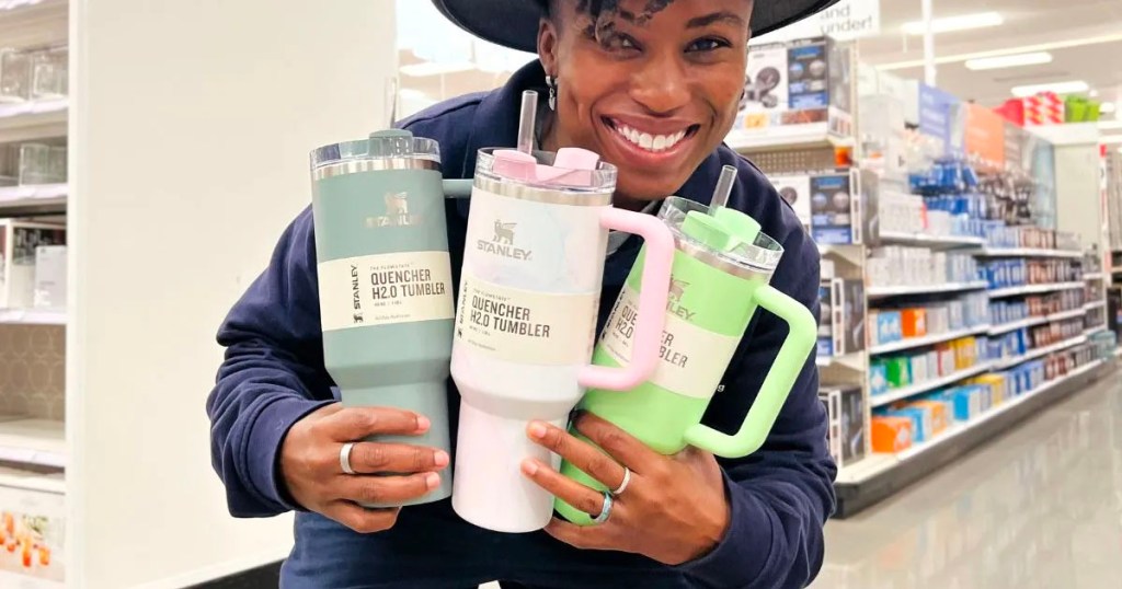 woman holding three stanley tumblers in target