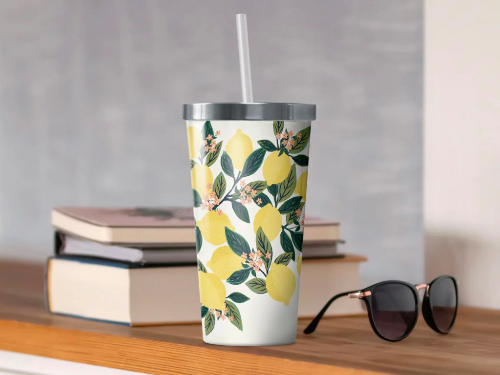 tumbler with lemons on it sitting on table next to sunglasses