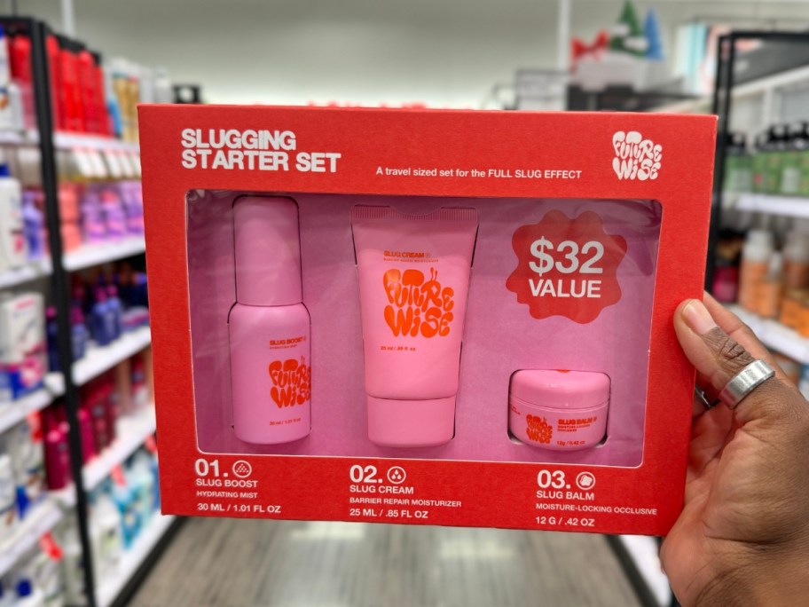 hand holding a red box with pink beauty products that's a Futurewise On the Go Slug Gift Set