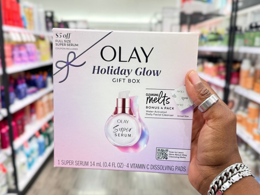 hand holding a pink box with a Olay Holiday Glow Kit featuring Super Serum Mini and Vitamin C Cleansing Melts Gift Set