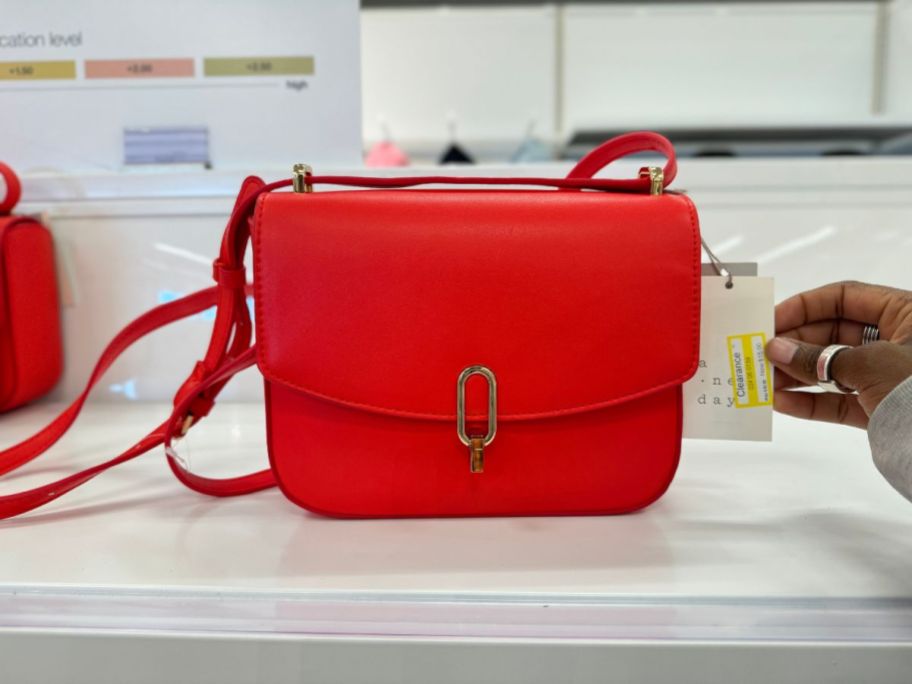 red handbag with flap on shelf