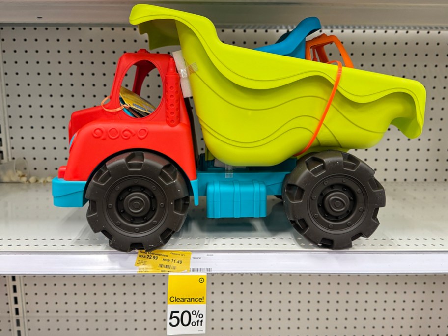 red and green dump truck toy on shelf