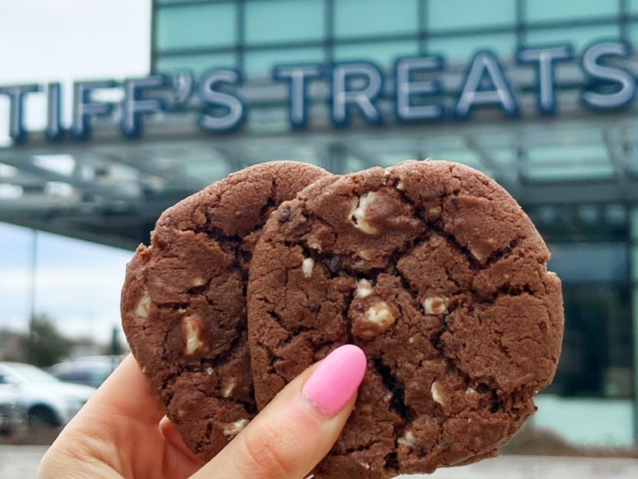 holding 2 chocolate cookies