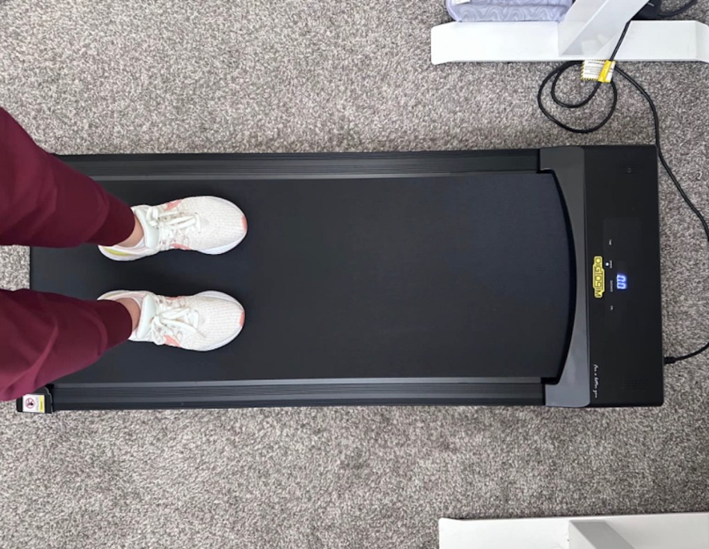 Person standing on walking pad under stand up desk