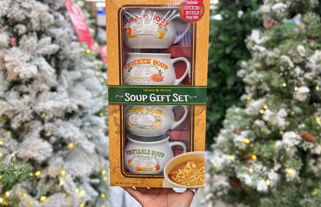 hand holding soup gift set in front of christmas trees