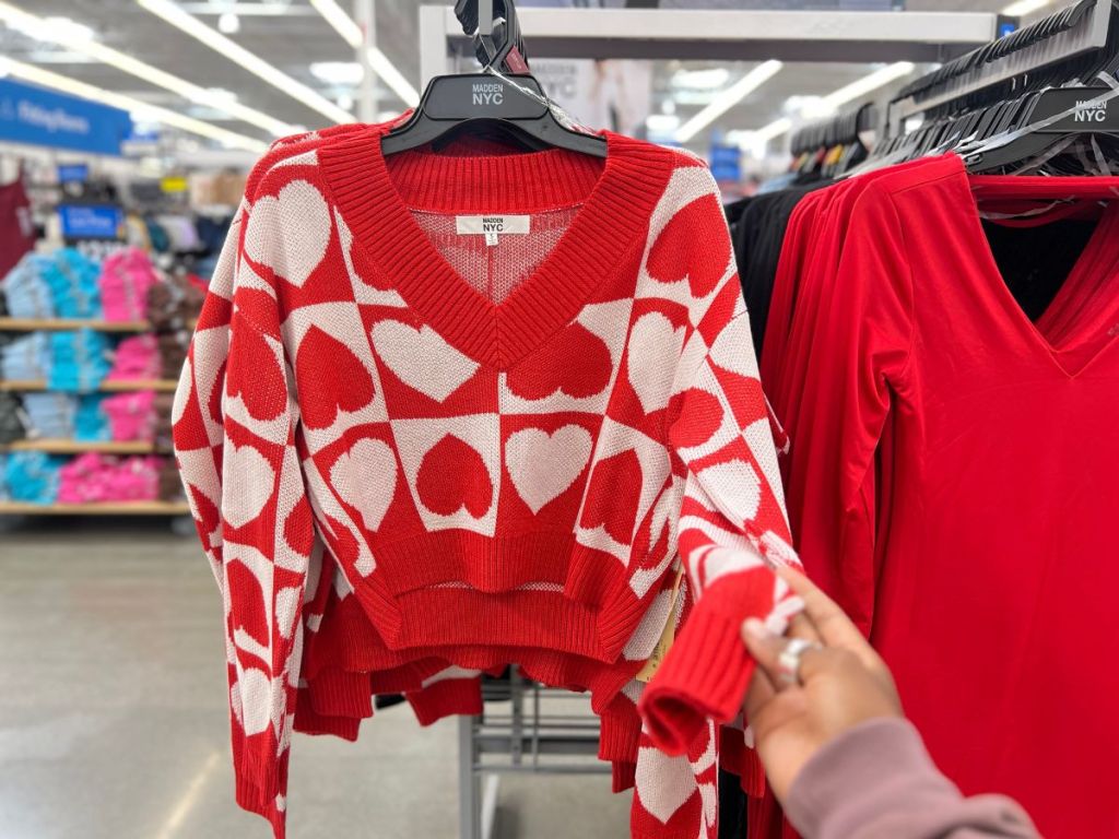 person grabbing sleeve of heart shaped sweater