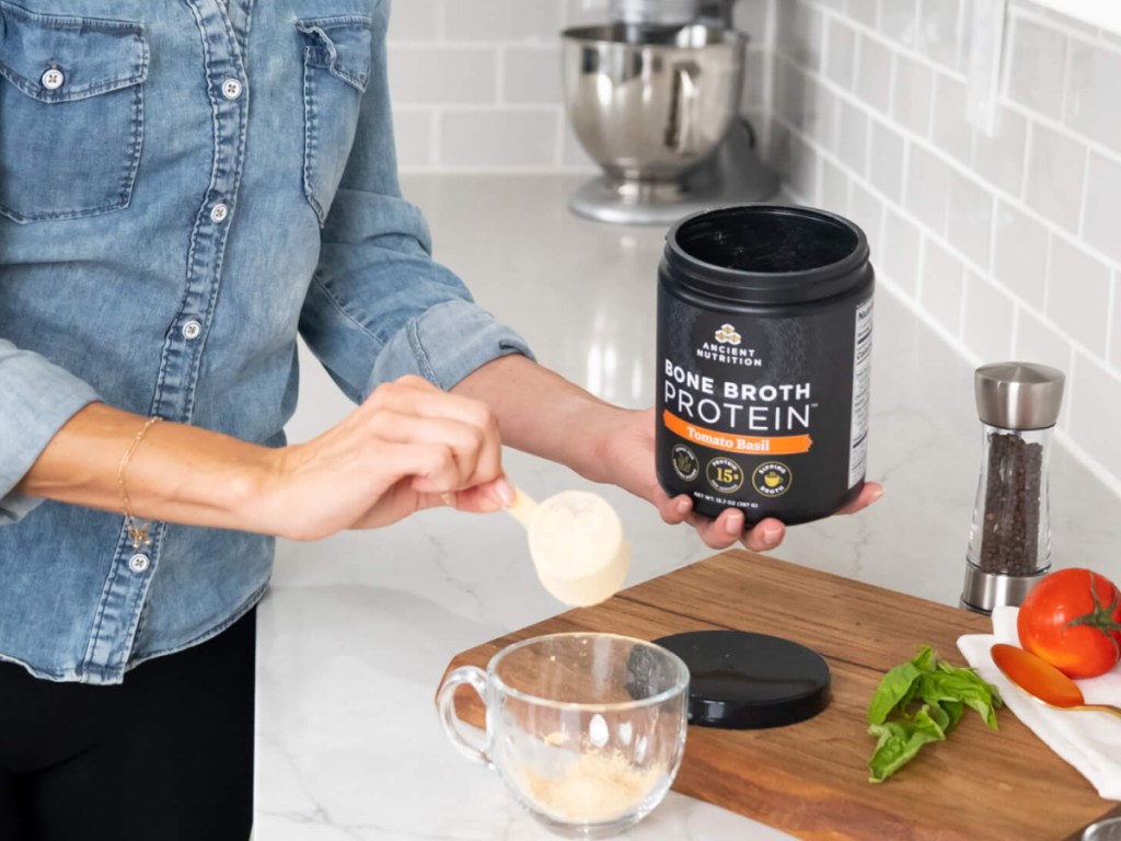 woman pouring bone broth protein into a cup
