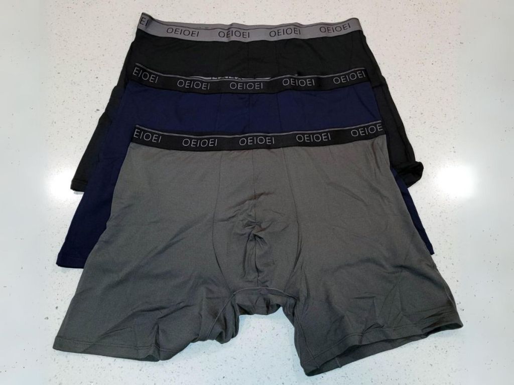 3 pair of men's boxer briefs in grey, navy and black laid out on counter