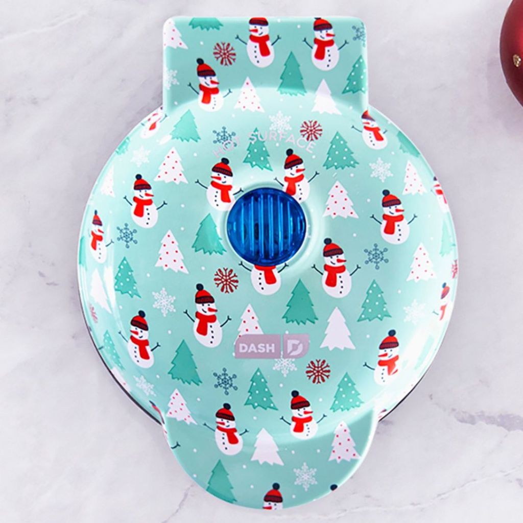 Dash Mini Waffle Maker, Aqua with Trees and Snowman sitting on counter