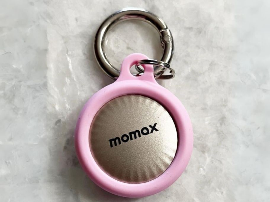 a gold Momax Tracker Tag in a pink keyring